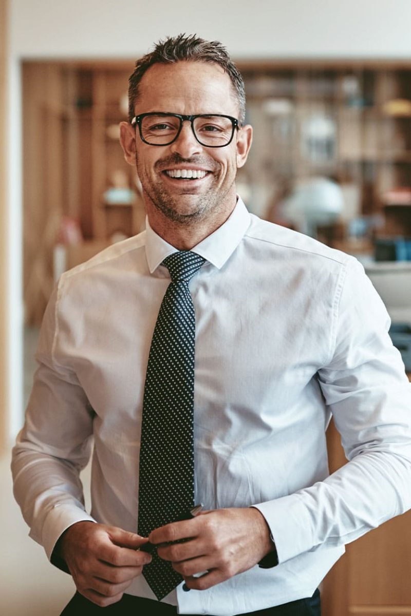 smiling-mature-businessman-standing-alone-in-an-of-GQBLE64.jpg